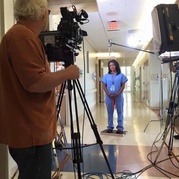 Camera man behind the scenes filming nurse for commercial